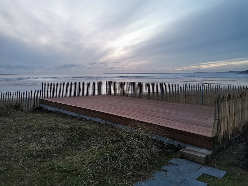 Terrasse bois surélevée face à la plage avec vue sur l'océan : terrasse en bord de mer réalisée en Bretagne par PMC.